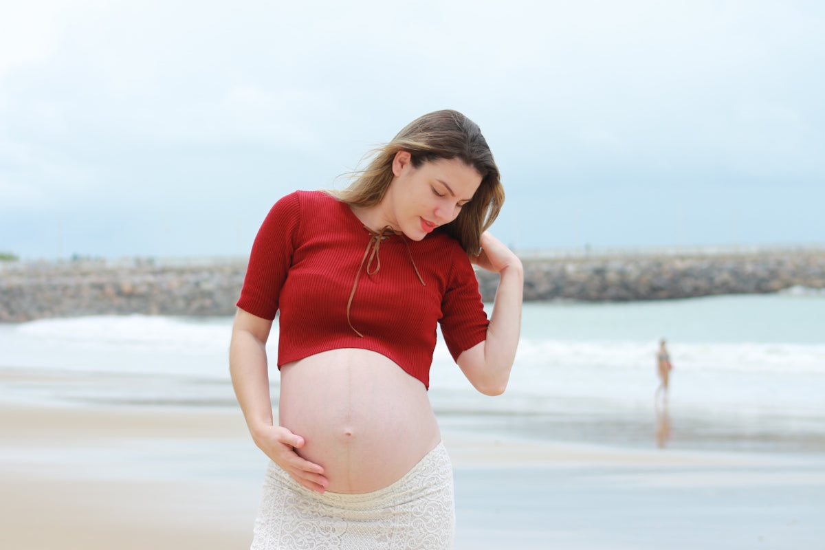 pregnant woman standing beside beach