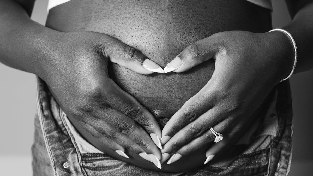a pregnant woman holding her belly in her hands