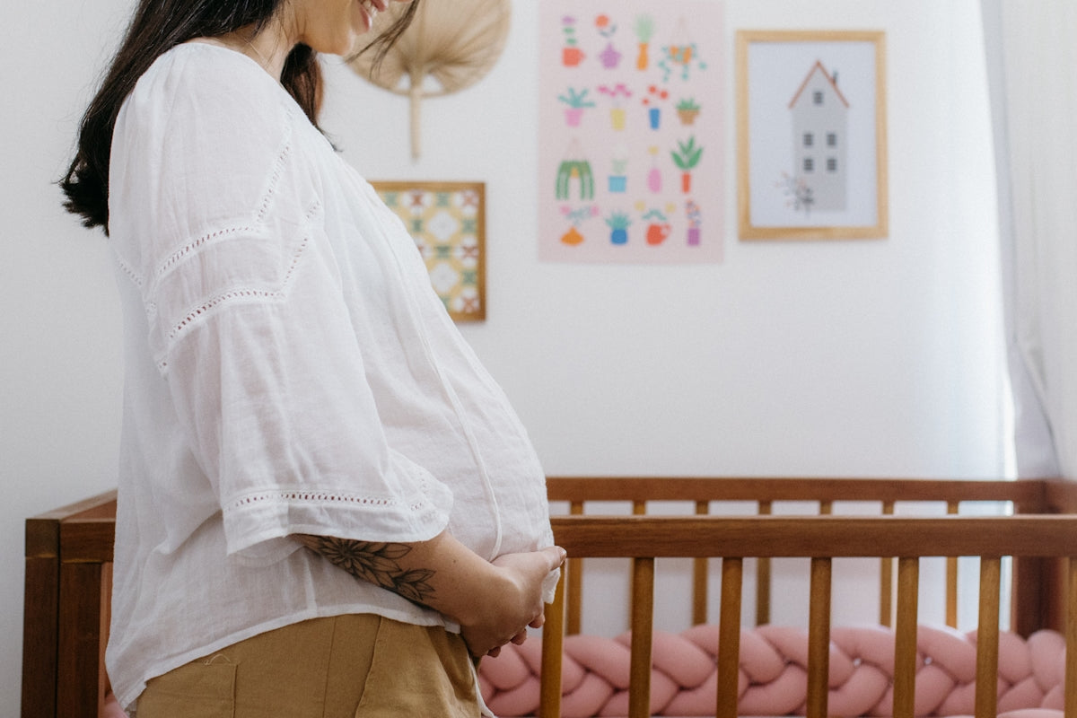 A woman standing next to a baby crib
