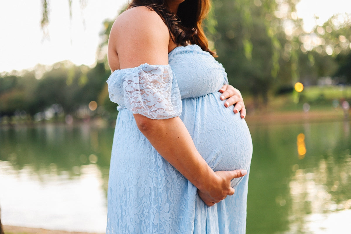 A pregnant woman holds her baby bump.