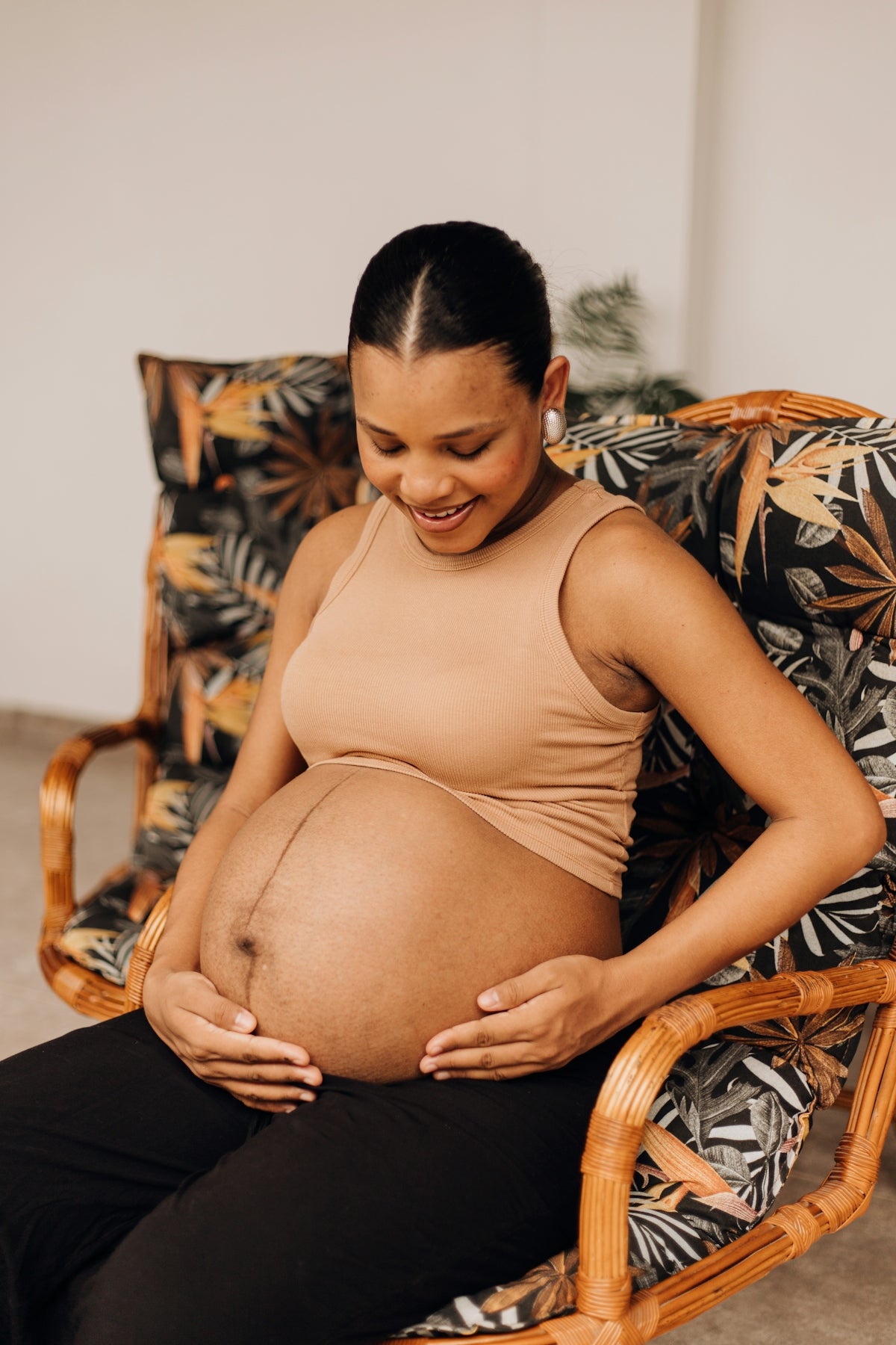 a pregnant woman sitting in a wicker chair