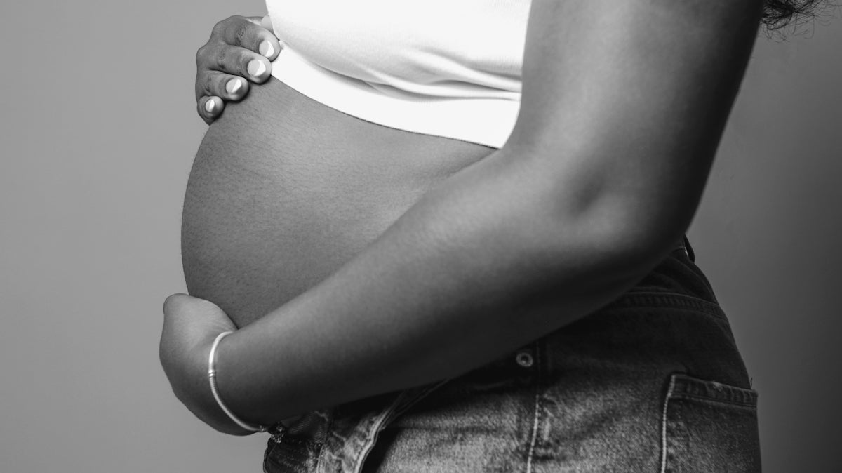 a pregnant woman holding her belly in her hands
