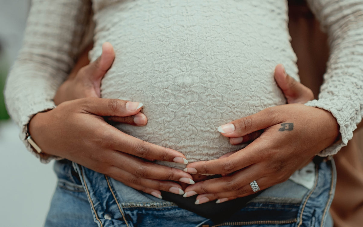 A pregnant woman holding her belly in her hands